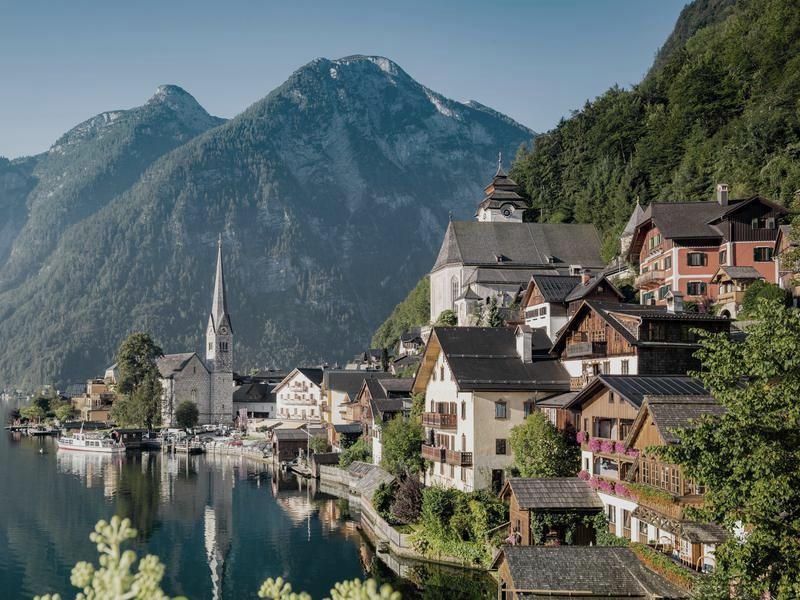 Hallstatt on its lake in Austria, the church spire and timber houses below wooded mountains