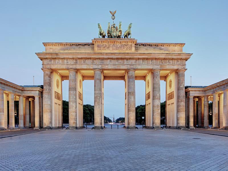The Brandenburg Gate in Berlin at dawn, the quadriga lit above an empty square